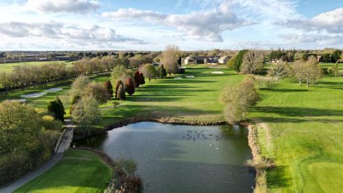 an aerial view of a golf course with a pond at Bicester Hotel, Golf & Spa in Bicester