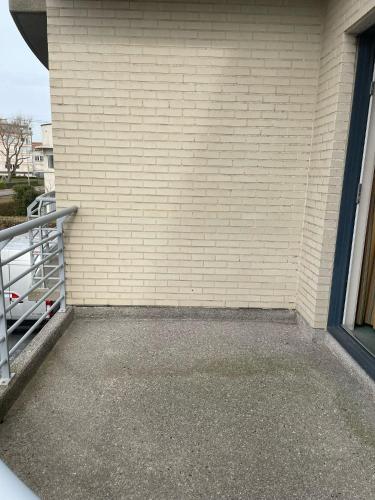 an empty parking lot next to a brick wall at Apparthotel De Wielingen in Westende Bad