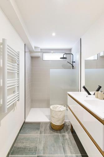 une salle de bain blanche avec un lavabo et un miroir dans l'établissement Impasse verte, à Saint-Quentin