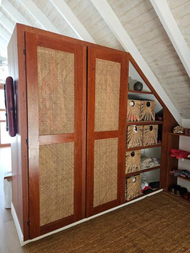 an attic room with a closet with a wooden door at Harbour View House Villa in Port Elizabeth