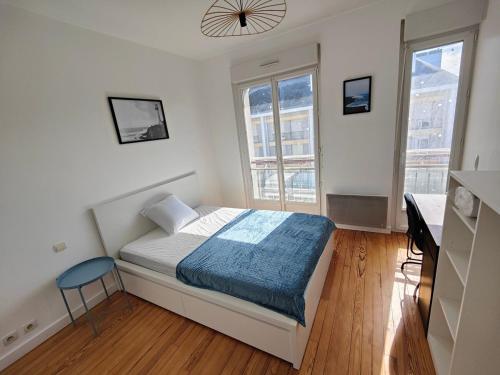 une petite chambre avec un lit et deux fenêtres dans l'établissement Le nid, 3 chambres proche mer, central, à Saint-Nazaire