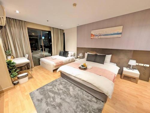 Un dormitorio con una cama grande y una sala de estar en Spacious and Renovated 1-Bedroom 100m to Nana BTS - 55 sqm, en Bangkok