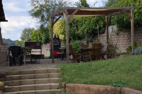 a patio with tables and chairs and a wooden canopy at Agriturismo Casale Contessa in Montebuono
