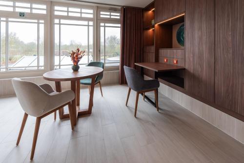 a dining room with a table and chairs and a window at B&B Carpe Diem in Westerlo