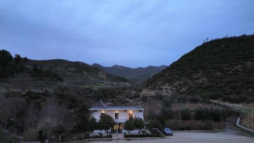 a house on a hill with mountains in the background at Hotel Eno in Përmet