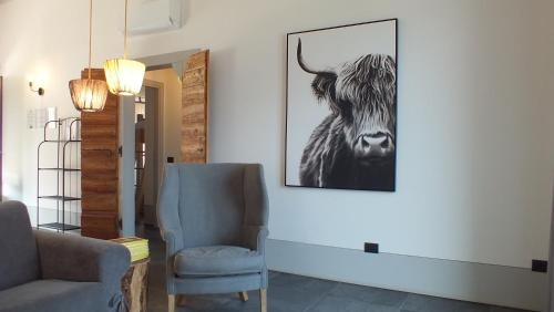 a living room with a picture of a cow on the wall at Rocca d'Anfo B&B-Apartments Lake View in Rocca dʼAnfo