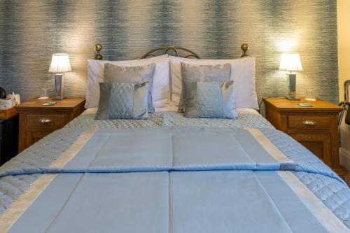 a bedroom with a bed with blue sheets and pillows at Harmony House Boutique B&B in Stillingfleet