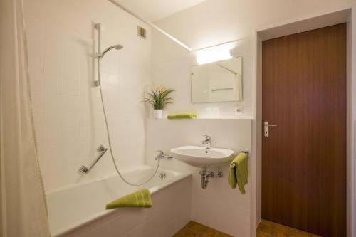 y baño con lavabo y bañera con lavamanos. en Bergschlössl - Massionettwohnung 16, en Oberaudorf