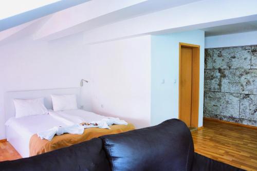 a bedroom with a bed and a couch at AMMOTTI Hotel in Ohrid