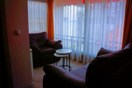 a living room with a couch and a chair and a table at AMMOTTI Hotel in Ohrid