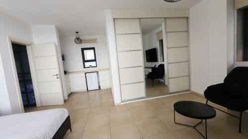 a bedroom with a mirror and a bed and a chair at Diamond Mansion-Studio D in Goren