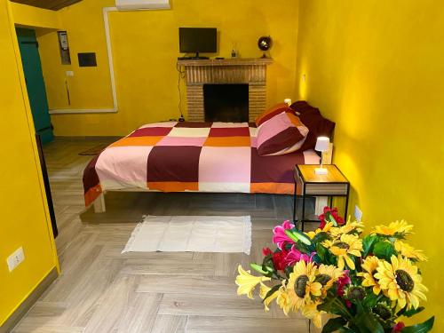 a bedroom with a bed with a fireplace and flowers at B&B il Parco stanza Garibaldi in Oriolo Romano