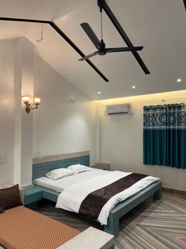 a bedroom with a bed and a ceiling fan at Amrapali Resort in Top