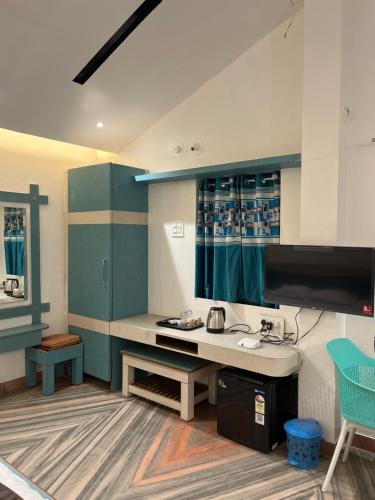 a room with a desk and a table with a monitor at Amrapali Resort in Top