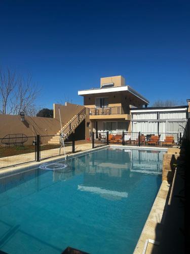 ein großes Schwimmbad vor einem Gebäude in der Unterkunft casa quincho concordia in Villa Zorraquín