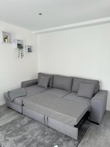 - un canapé gris dans une chambre dotée d'un mur blanc dans l'établissement Appartement 4 personnes, à Vitry-sur-Seine