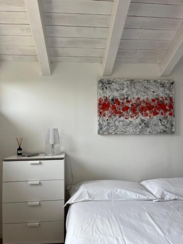 a bedroom with a bed and a painting on the wall at Chalet Ai Grecc in Mezzolago
