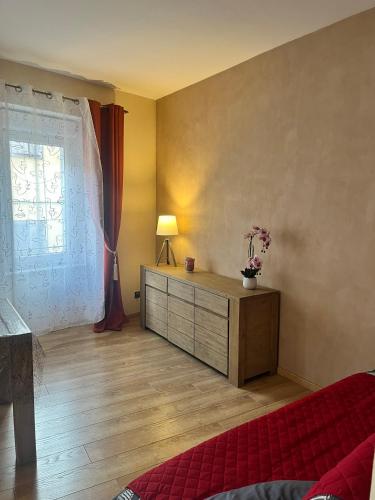 a bedroom with a bed and a dresser with a window at Hôtel Restaurant Les Arcades in Limoux