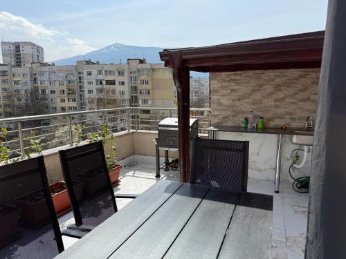 a balcony with a table and a grill on a roof at Apartment near Vitosha mountain, self check-in, with underground parking in Sofia