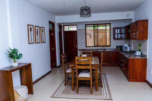 a kitchen with a table and chairs in a room at Timeless Stays in Arusha