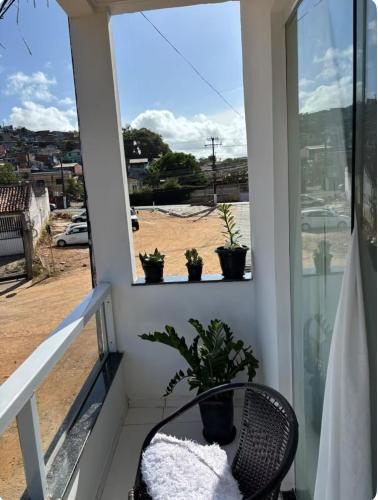 a balcony with a chair and potted plants at Casa de Praia na Barra, Ilhéus in Ilhéus