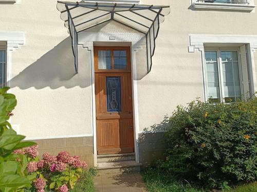 une porte d'une maison avec un parasol dans l'établissement Chambre d'hôte au Mans pour 24H Autos Motos ou autre évènement, au Mans