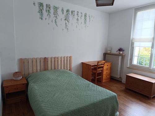 une chambre avec un lit avec une couette verte dans l'établissement Chambre d'hôte au Mans pour 24H Autos Motos ou autre évènement, au Mans