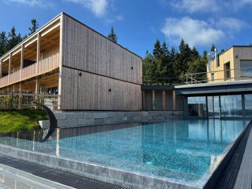 a large swimming pool in front of a building at Hunderesort Waldeck - 4 Sterne Urlaub mit Hund in Philippsreut