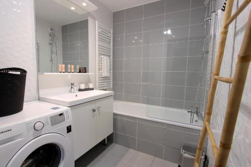 une salle de bain avec une machine à laver et un lavabo dans l'établissement NOVA4- Cozy Apartment 8 ppl- Near Disneyland Paris, à Serris