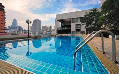 a swimming pool with blue tiles on a building at Cozy, Spacious 2-Bedder with City, Park View, Near Nana BTS in Bangkok