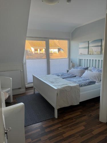 a bedroom with a bed and a large window at Pension Mien Fründt in Baabe