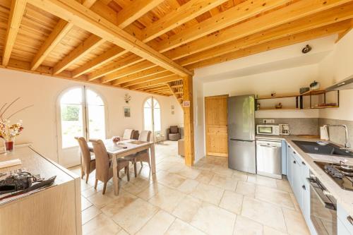 une cuisine avec une table et une salle à manger dans l'établissement Gite 4 places, le Domaine de la Vallée, à Saint-Martin-de-Varreville