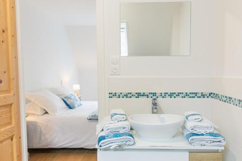 a bathroom with a sink and a bed at Gite 4 places, le Domaine de la Vallée in Saint-Martin-de-Varreville
