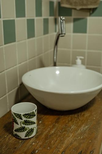 a white sink sitting on top of a wooden table at Espaço CurAmar - Praia de Itamambuca in Ubatuba