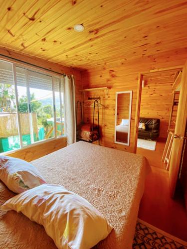 a bedroom with a bed and a large window at Linda cabaña con excelente vista panorámica in Piriápolis
