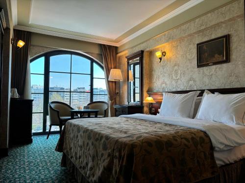 a hotel room with a bed and a large window at Germir Palas Hotel - Special Class in Istanbul