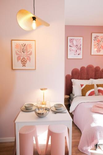 - une chambre rose avec un lit, une table et des tabourets dans l'établissement Casa Luna, à Nice
