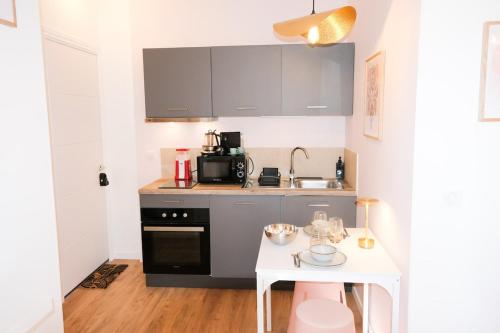 - une petite cuisine avec une table blanche et un comptoir dans l'établissement Casa Luna, à Nice