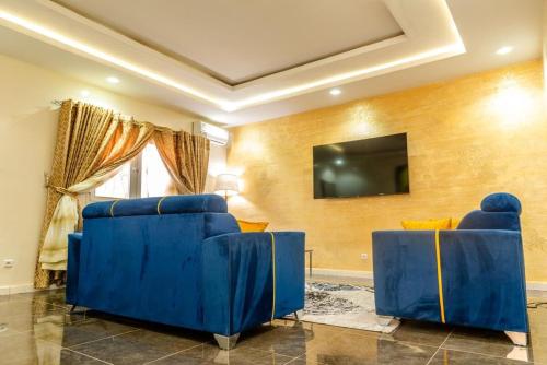 a room with blue chairs and a flat screen tv at Appartement Somone , Sall Residence in Mbour
