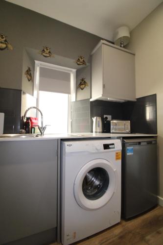 a kitchen with a washing machine and a sink at Links Cottage, Prestwick in Prestwick