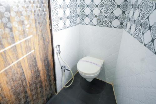 a small bathroom with a toilet and a shower at Hotel Skylink Hospitality Mahalaxmi in Mumbai
