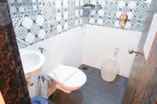 a bathroom with a toilet and a sink at Hotel Skylink Hospitality Mahalaxmi in Mumbai