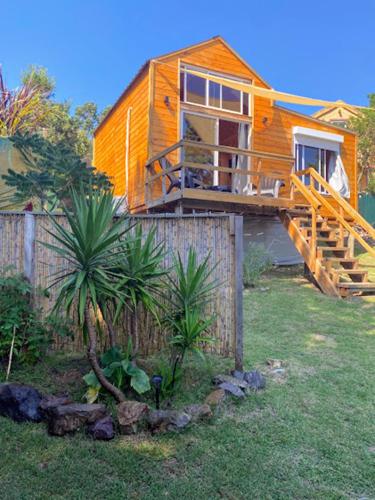 a wooden house with a deck and a fence at Linda cabaña con excelente vista panorámica in Piriápolis