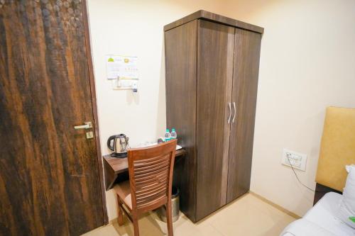 a wooden cabinet next to a desk in a room at Hotel Skylink Hospitality Mahalaxmi in Mumbai