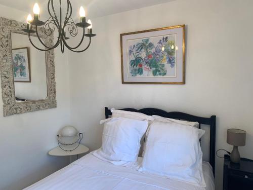 - une chambre avec un lit doté d'oreillers blancs et d'un miroir dans l'établissement French Riviera Villa, à Biot