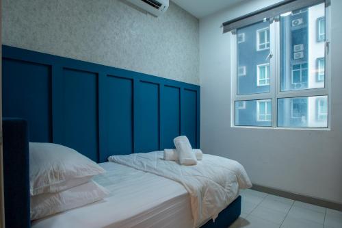 a bedroom with a bed with a blue headboard and a window at In Centre Kuala Terengganu Home in Kuala Terengganu