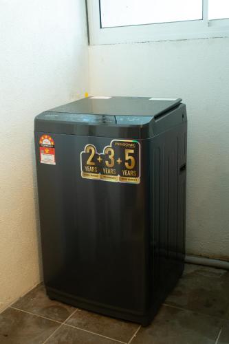 a black trash can with a clock on it at In Centre Kuala Terengganu Home in Kuala Terengganu