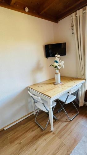 Una mesa blanca con un jarrón de flores. en Duplex with panoramic view, en Allos