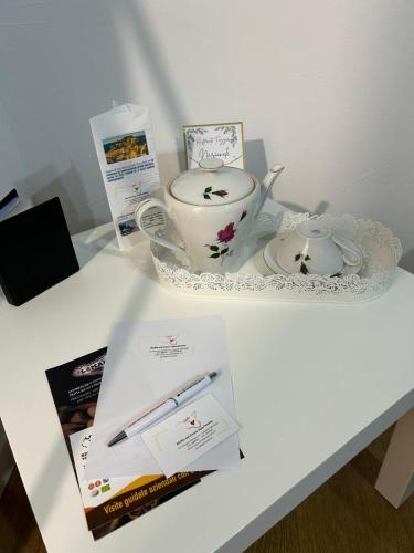 a white table with a tea pot and a book at Sicilia nel Cuore Apartment in Cassibile