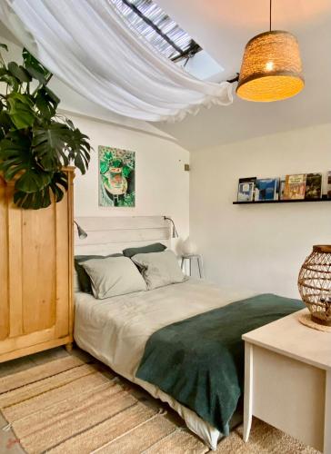 une chambre avec un lit et une plante en pot dans l'établissement L'Atelier, à Montigny-sur-Loing